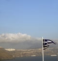 Flag Greece flying over caldera Oia Santorini Royalty Free Stock Photo