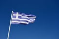 The flag of Greece. Flying in the wind against the blue sky. Corfu Island - Greece. Concept for summer holidays and vacation Royalty Free Stock Photo