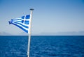 Flag of Greece waving over blue sea waters Royalty Free Stock Photo