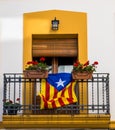 The flag of independent Catalonia flutters on the balcony, decorated with potted flowers. Spain