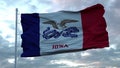 Flag of Iowa waving in the wind against deep beautiful clouds sky. 3d rendering