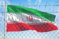 Flag of Iran behind barbed wire fence. Concept of sanctions, embargo, dictatorship, discrimination and violation of human rights