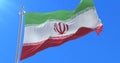 Flag of Iran waving at wind in slow in blue sky, loop