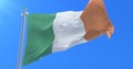 Flag of Ireland waving at wind in slow in blue sky, loop