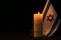 Flag of Israel, barbed wire and burning candle on black background, space for text. Holocaust memory day Royalty Free Stock Photo
