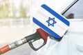 Flag of Israel on the car`s fuel filler flap with gas pump nozzle in the tank Royalty Free Stock Photo