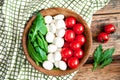 Flag of Italy from ingredients for vegetarian healthy salad - cherry tomato, mozzarella cheese and arugula on a wooden plate.