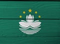 Flag of Macau on wooden wall background. Grunge Macau flag texture.