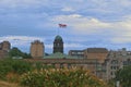 Flag of McGill university flies in the air in a windy day with a background of cloudy blue sky and a foreground of a garden Royalty Free Stock Photo