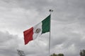 The flag of Mexico flying on a cloudy day with a lot of wind, a sky full of clouds in the background