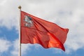 Flag of the Moscow region on the pole against the background of the cloudy sky, close-up. Red banner with the image of Royalty Free Stock Photo