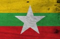 Flag of Myanmar on wooden plate background. Grunge Myanmarese flag texture.
