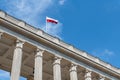 Flag of Poland on top of the building on blue sky background