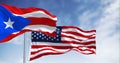 Flag of Puerto Rico waving with the United States flag on a clear day Royalty Free Stock Photo
