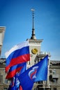 The flag of Russia develops together with the flag of the United Russia party against the background of a house under a spire