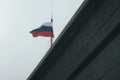 The flag of Russia is a national symbol in the wind. The Russian flag flutters in the wind against a white cloudy sky Royalty Free Stock Photo