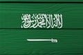 Flag of Saudi Arabia on wooden wall background. Grunge Saudi Arabia flag texture.