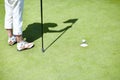 Flag, shoes or person playing golf for fitness, workout or exercise with ball shadow on a green course. Legs of golfer Royalty Free Stock Photo