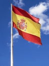 Flag of Spain waving on a blue sky. Royalty Free Stock Photo