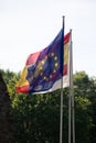 Flag of Spain and the European Union together and superimposed waving in front of the blue sky