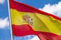 Flag of Spain waving in the wind on flagpole against the sky with clouds Royalty Free Stock Photo