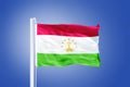 Flag of Tajikistan flying against a blue sky