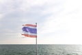 Flag of Thailand waving in the front of a ferry ship sailing in Andaman Sea