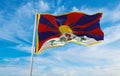 flag of Tibet at cloudy sky background on sunset, panoramic view. People\'s Republic of China. copy space for wide banner