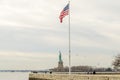 Flag of the United States of America with Lady Liberty Statue in Background. Manhattan, New York City, USA Royalty Free Stock Photo