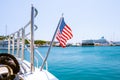The flag of the United States flutters in the wind on a stainless steel flagpole at the stern of a motor yacht. Marina in the port Royalty Free Stock Photo