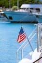 The flag of the United States flutters in the wind on a stainless steel flagpole at the stern of a motor yacht. Marina in the port Royalty Free Stock Photo