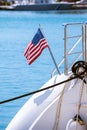 The flag of the United States flutters in the wind on a stainless steel flagpole at the stern of a motor yacht. Marina in the port Royalty Free Stock Photo