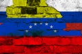 Flag of Venezuela and Russia on the background of a brick wall with broken plaster