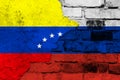 Flag of Venezuela and Russia on the background of a brick wall with broken plaster