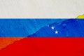 Flag of Venezuela and Russia on the background of the texture of frayed paint with a crack on the whole frame