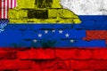 Flag of Venezuela, Russia and the USA on a brick wall background with broken plaster