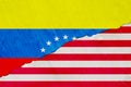 Flag of Venezuela and USA on the background texture of the shabby paint with a crack on the whole frame