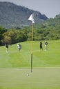 Flagpole, Balls, Green, Fairway, & Blurred Players Royalty Free Stock Photo