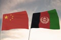 Flags of Afghanistan and China waving with cloudy blue sky background, 3D rendering