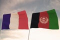 Flags of Afghanistan and France waving with cloudy blue sky background, 3D rendering