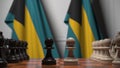 Chess game against flags of Bahamas. Political competition related 3D rendering