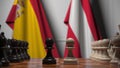 Flags of Spain and Austria behind pawns on the chessboard. Chess game or political rivalry related 3D rendering