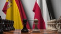 Flags of Spain and Poland behind pawns on the chessboard. Chess game or political rivalry related 3D rendering
