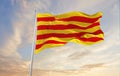 flags of Catalonia waving in the wind on flagpoles against sky with sunset clouds on sunny day. Symbolizing patriotism. 3d Royalty Free Stock Photo
