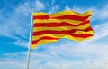 flags of Catalonia waving in the wind on flagpoles against sky with sunset clouds on sunny day. Symbolizing patriotism. 3d Royalty Free Stock Photo