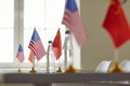 Flags of China and America on conference table symbolizing cooperation between two countries.