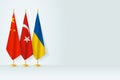 Flags of China, Turkey and Ukraine stand in row on indoor flagpole