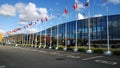 Flags of different countries on flagpoles against blue sky near Congress and exhibition expo centre Expoforum. International coope