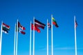 Flags of Different Countries Hang On Flagpoles Against Blue Sky. Flag of Latvia, Canada, UK, Italy, Estonia and China. The concept Royalty Free Stock Photo
