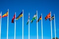 Flags of Different Countries Hang On Flagpoles Against Blue Sky. Flag of Spain, Ukraine, Germany, Sweden, Turkey, Uzbekistan and Royalty Free Stock Photo